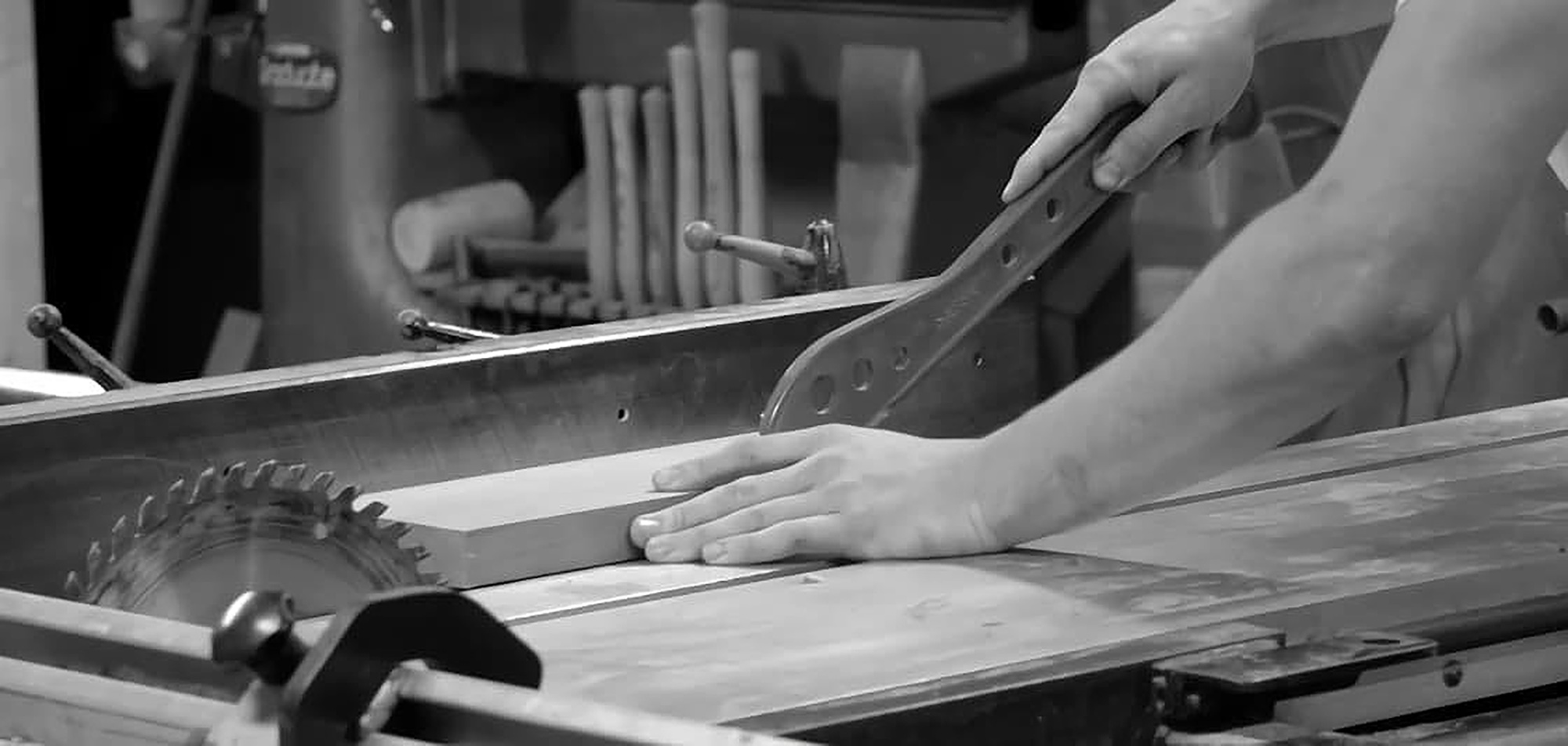 Black and white image of a carpenter cutting wood with a jigsaw
